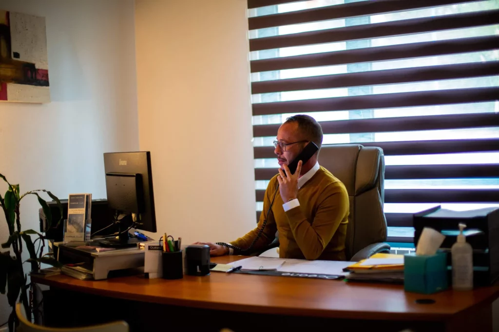 Conseiller funéraire répondant au téléphone à son bureau dans une agence
